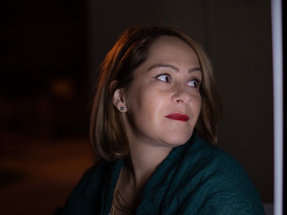 a woman in a green shirt looking up at something