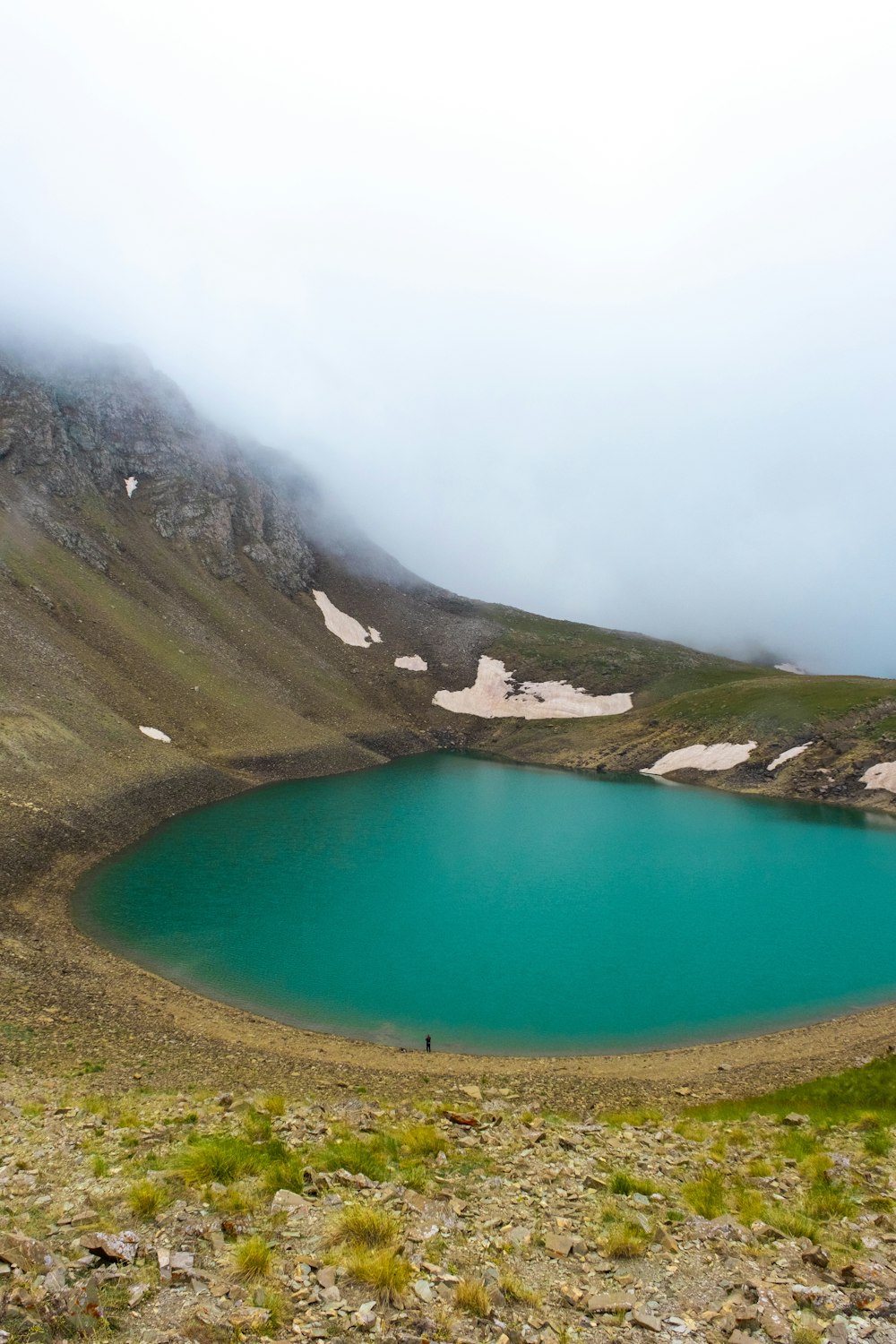 um grande lago azul cercado por uma montanha