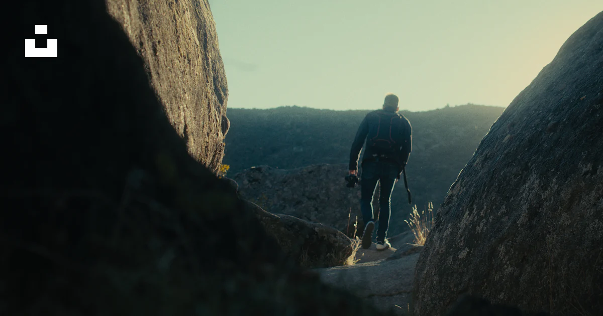 A man standing in between two large rocks photo – Free Nature Image on ...