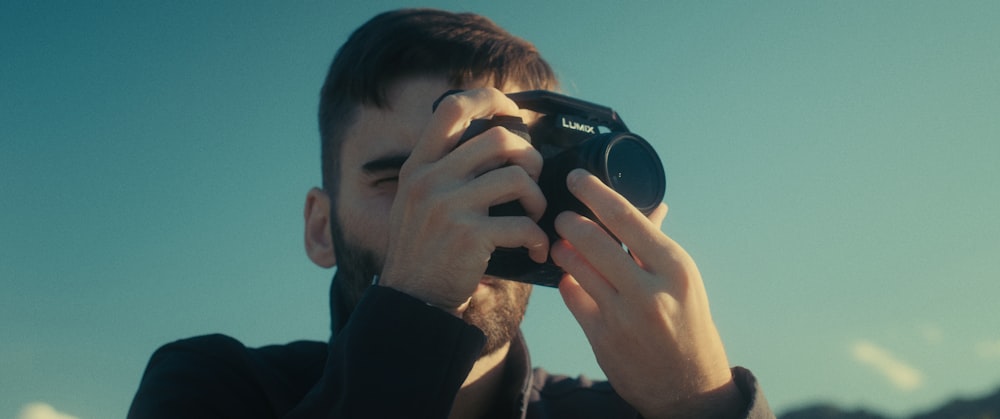 a man holding a camera up to his face