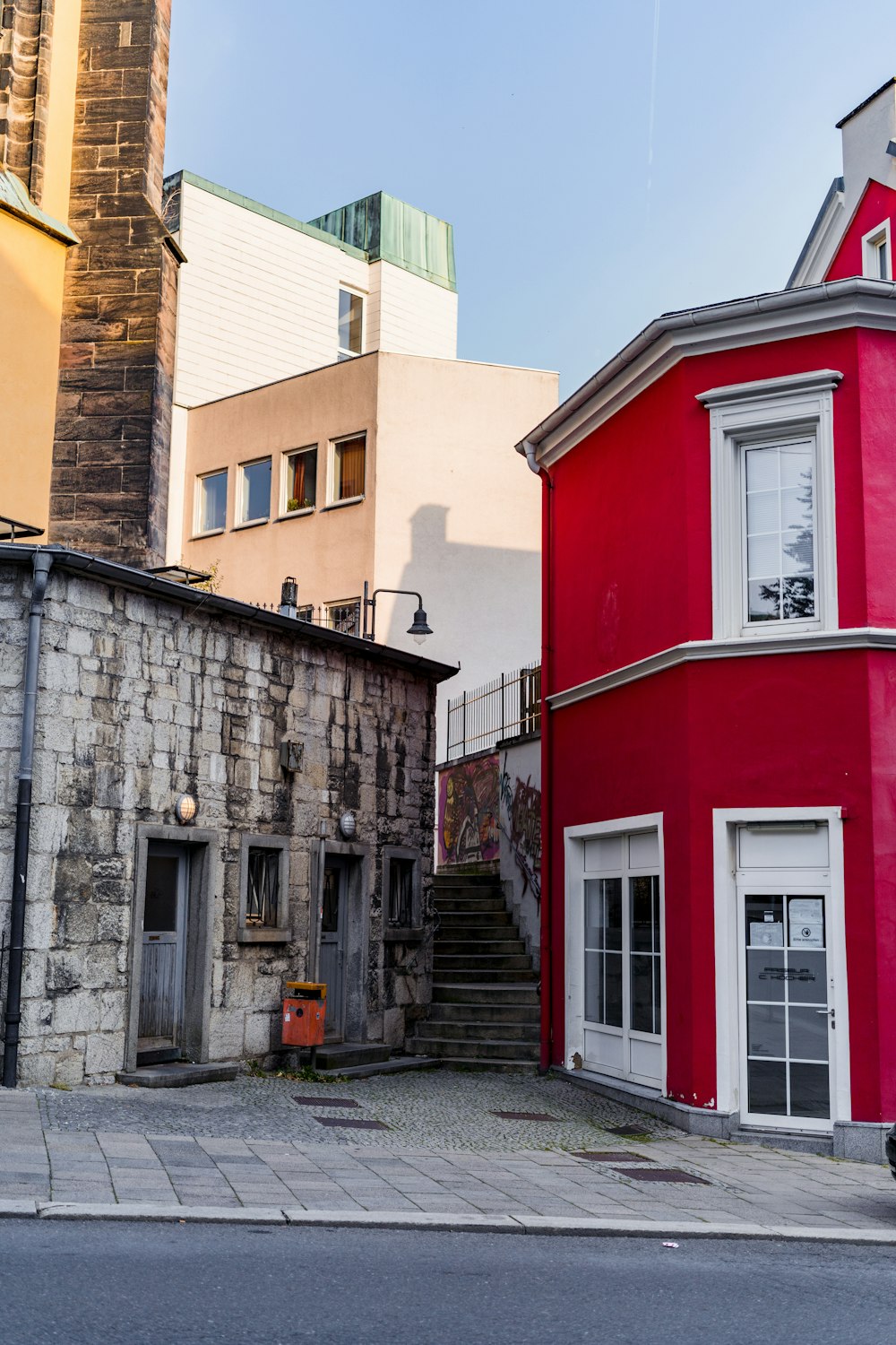 a red building sitting next to a tall brick building