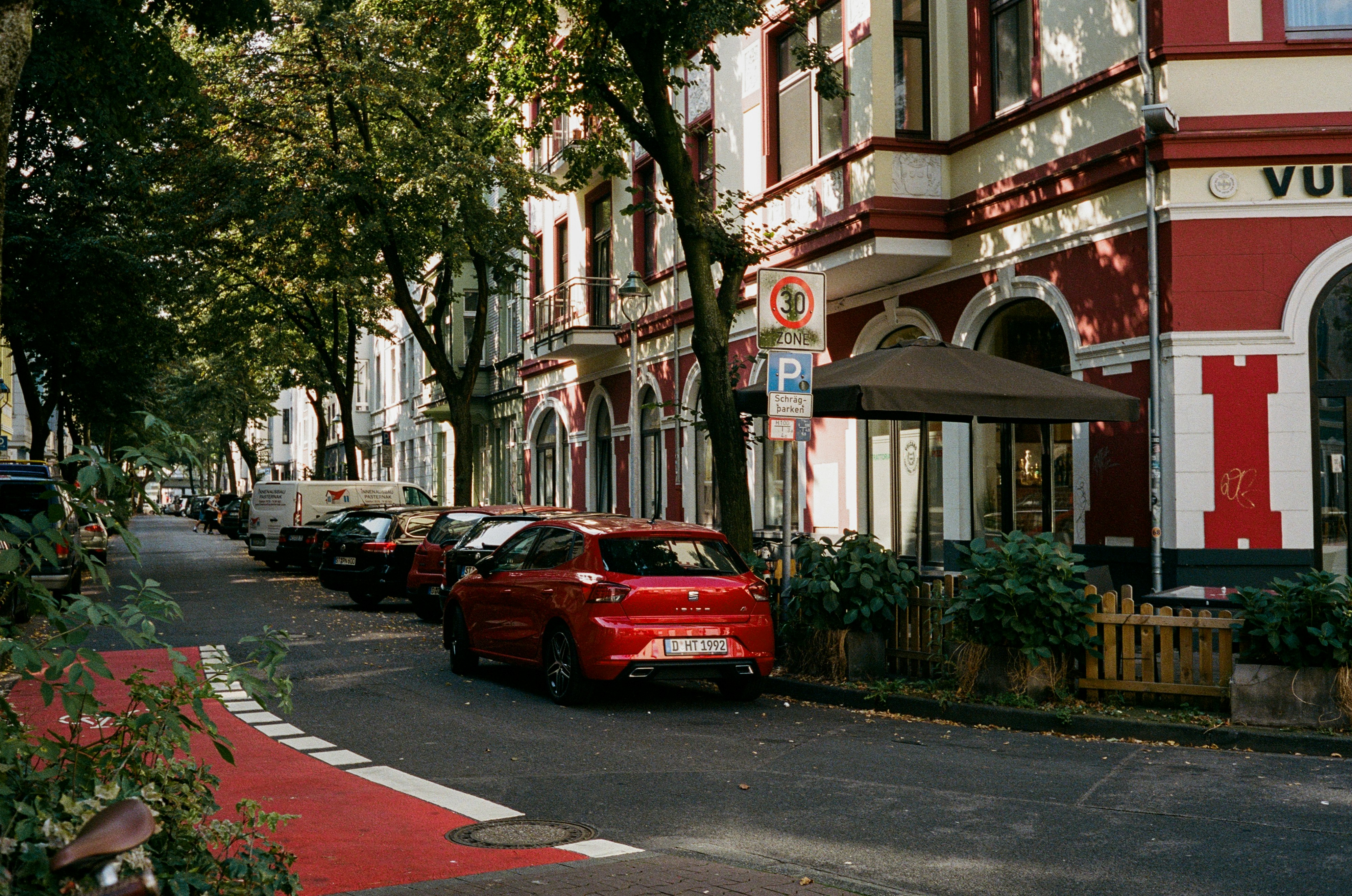 A row of parked cars sitting on the side of a road photo – Free Germany ...