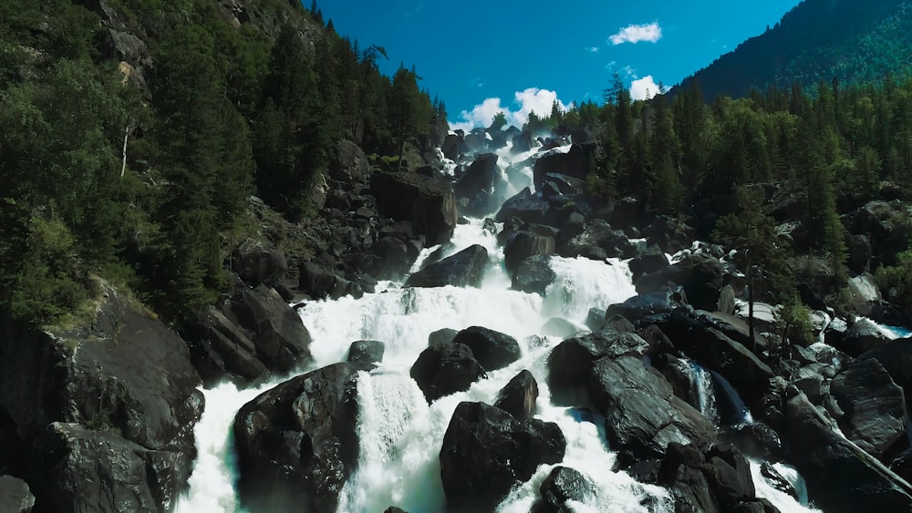 a large waterfall surrounded by rocks and trees