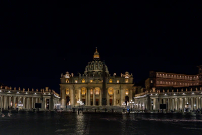 Nighttime illumination highlighting the basilica’s unique architectural shapes.