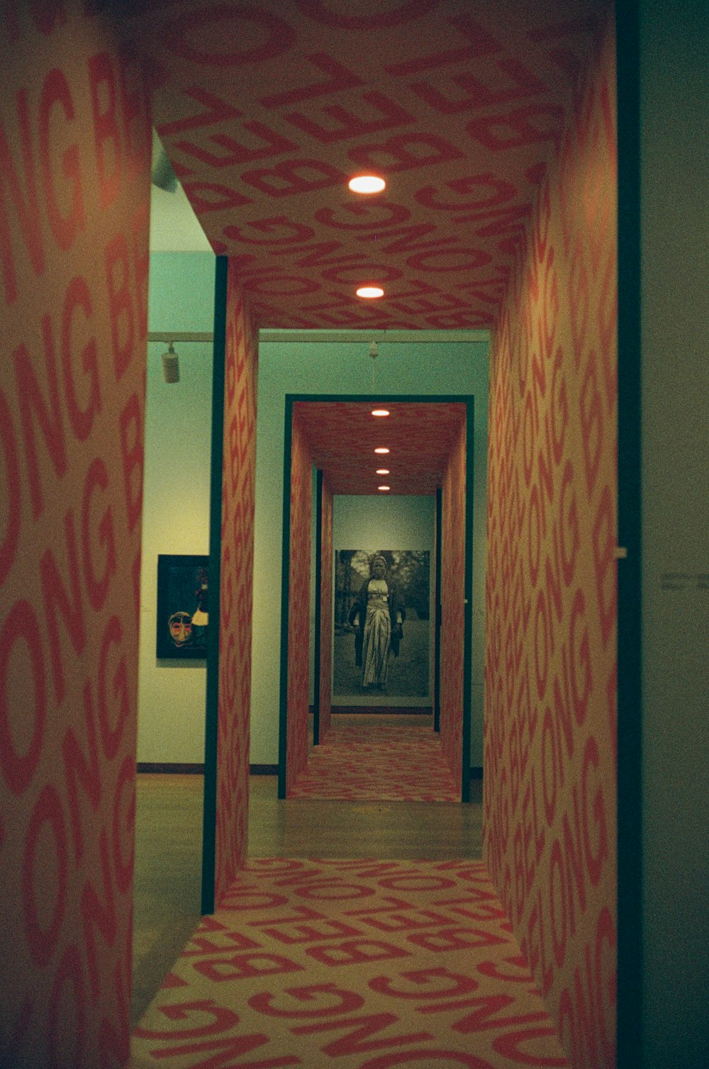 a long hallway with a red and white pattern on the wall