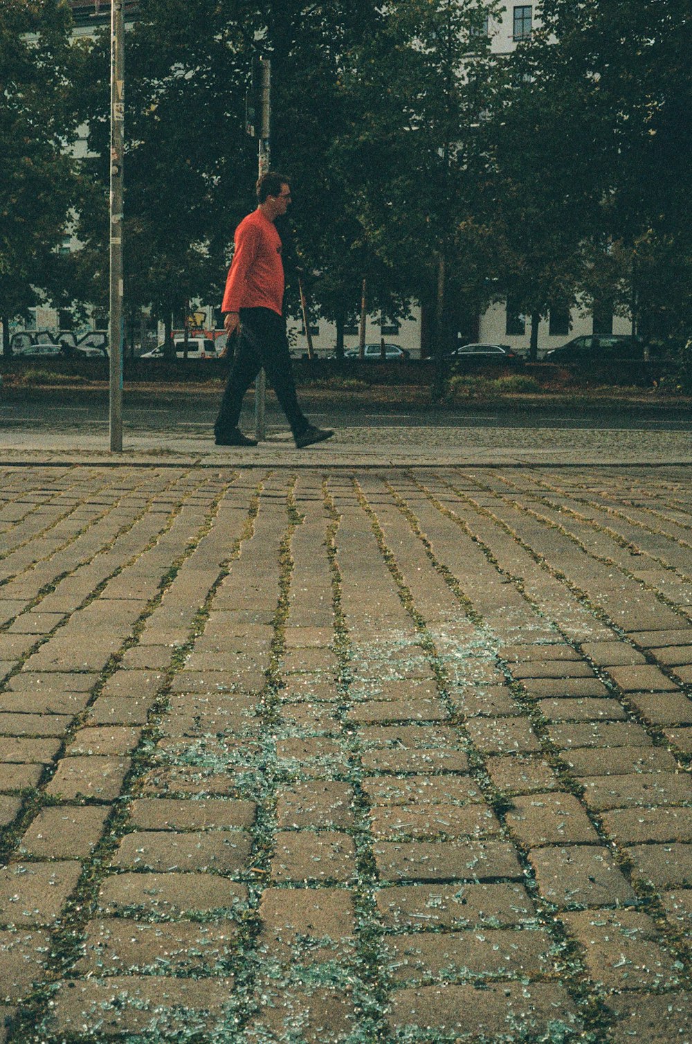 a man walking down a street next to a stop sign