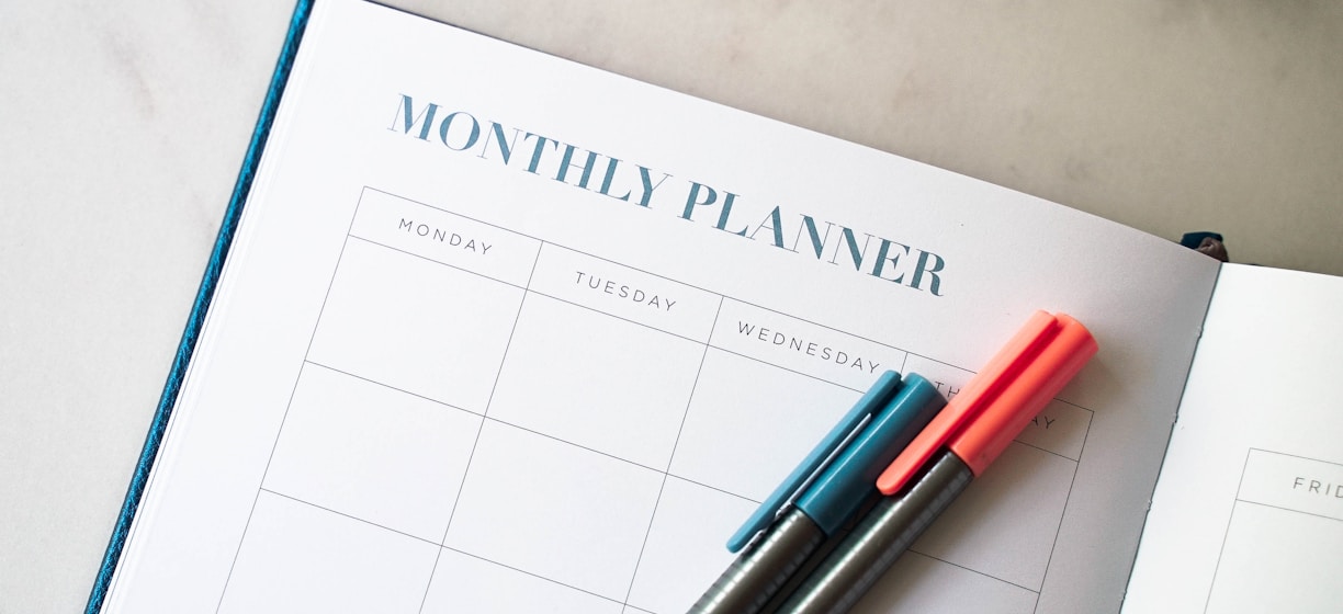 a planner with two pens sitting on top of it