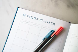 a planner with two pens sitting on top of it