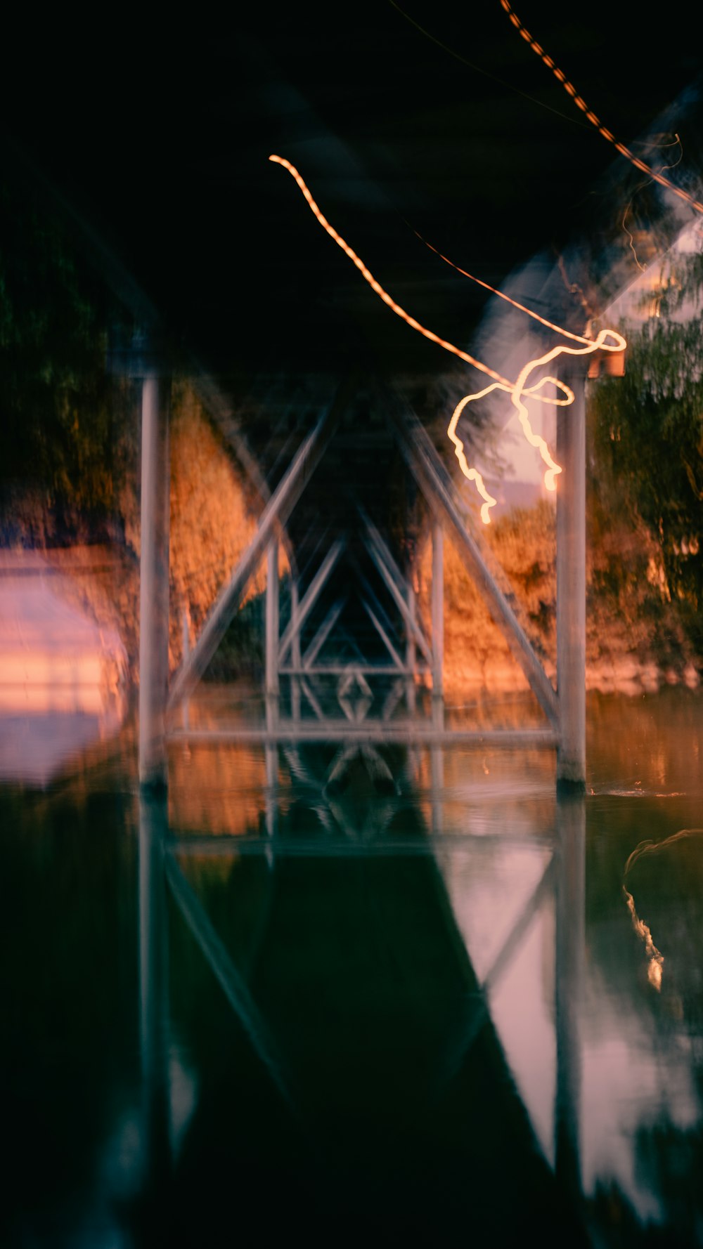 a blurry photo of a bridge over a body of water