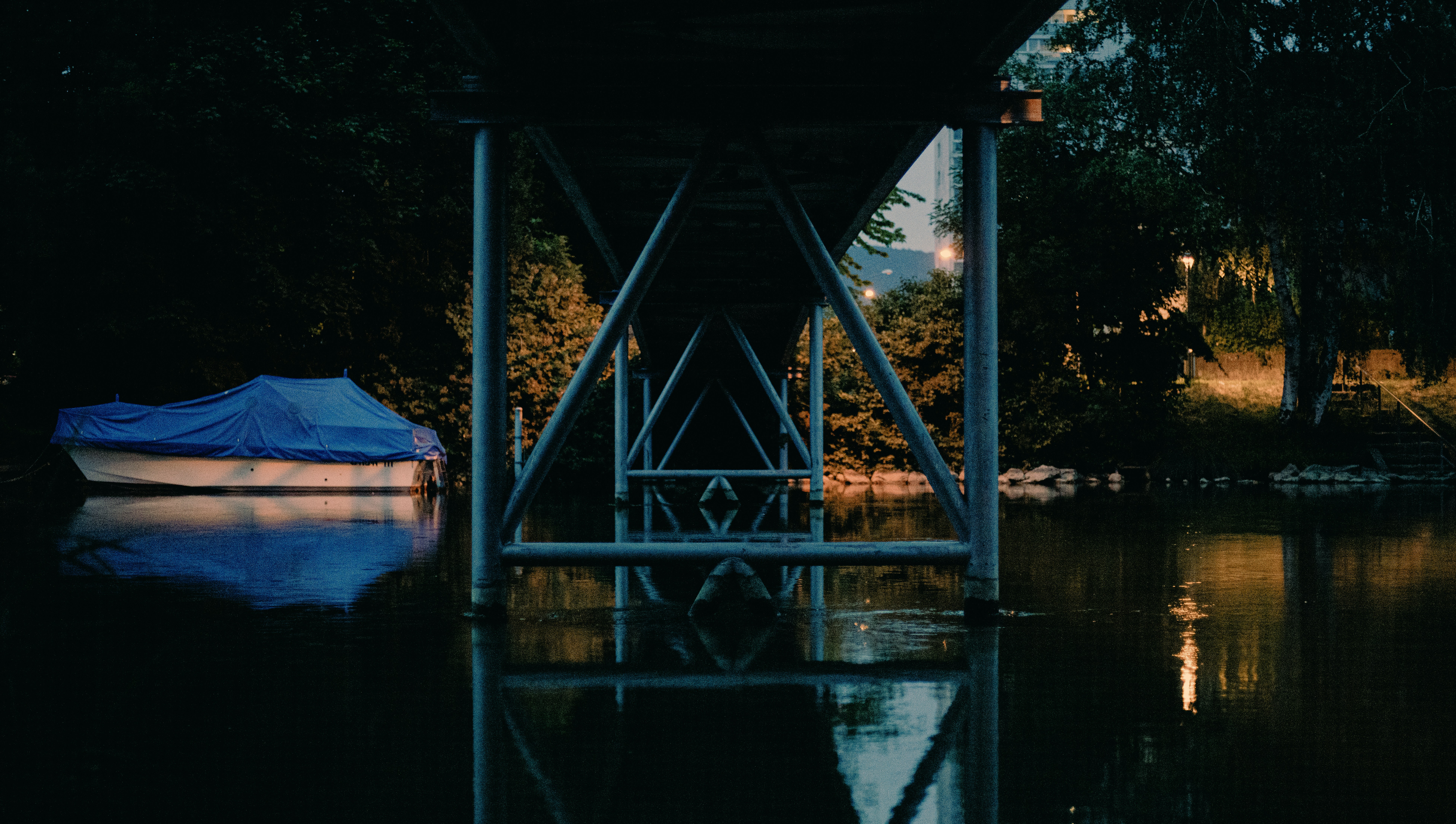 a boat sitting under a bridge at night