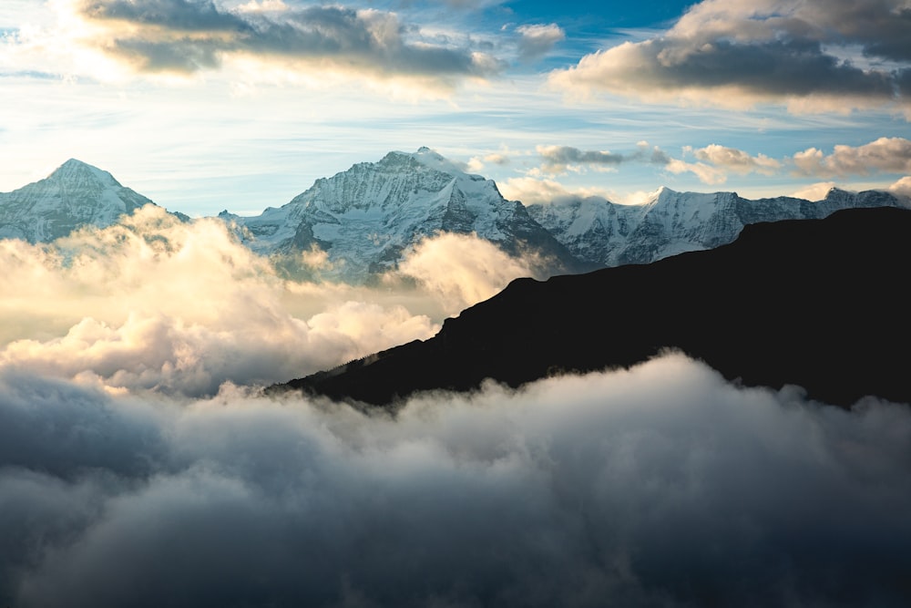 a view of a mountain range with clouds in the foreground