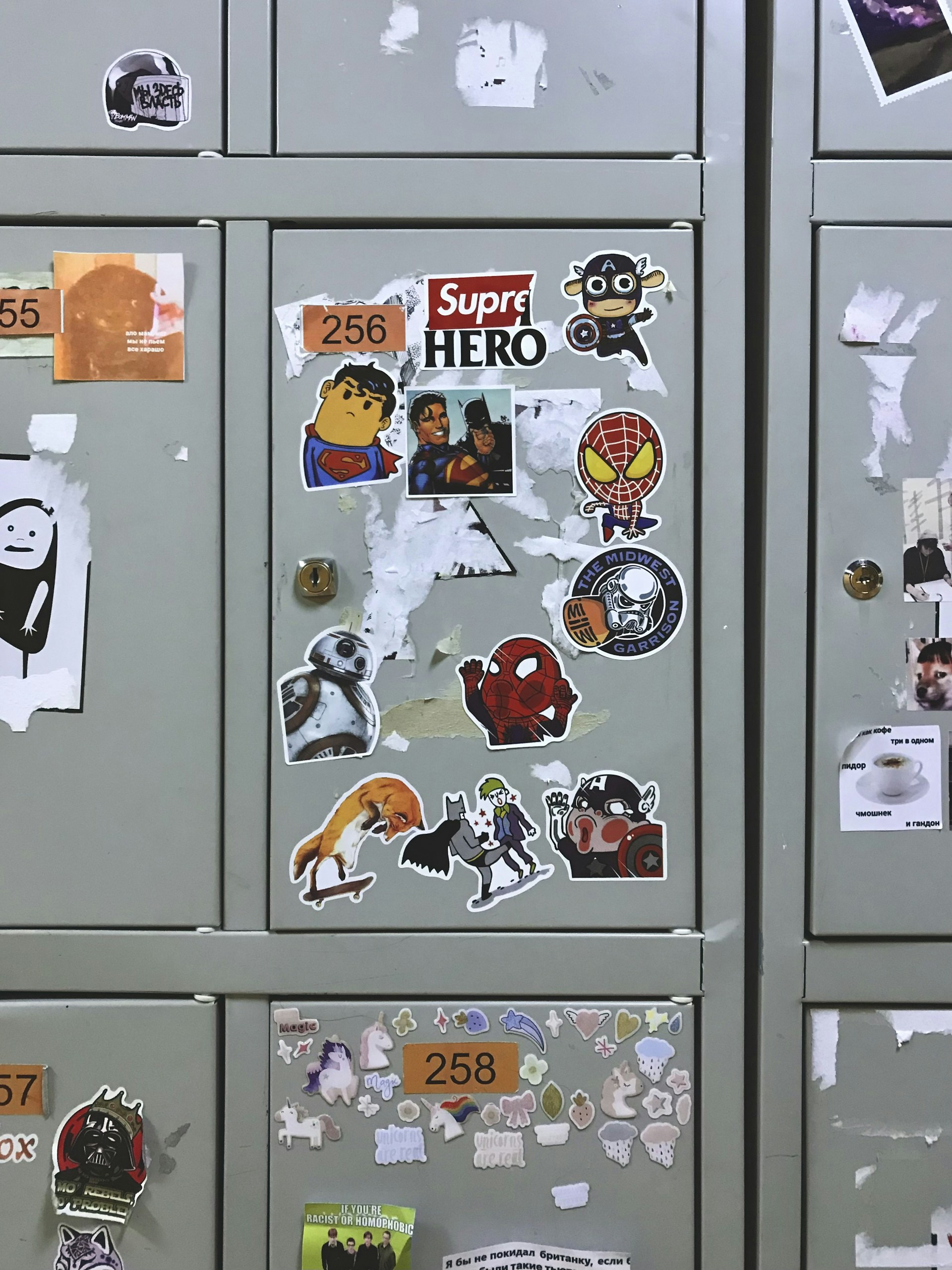 A close-up of a vintage locker decorated with rose stickers and notebook doodles, with a deep blue varsity jacket hanging on the side.