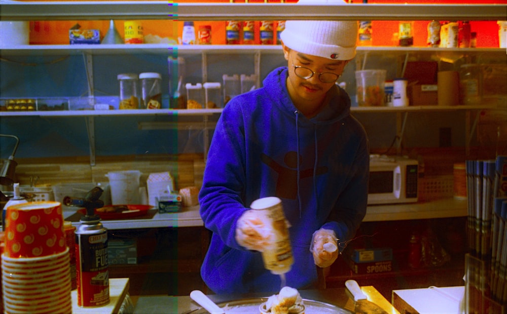 a man in a kitchen preparing food on a plate