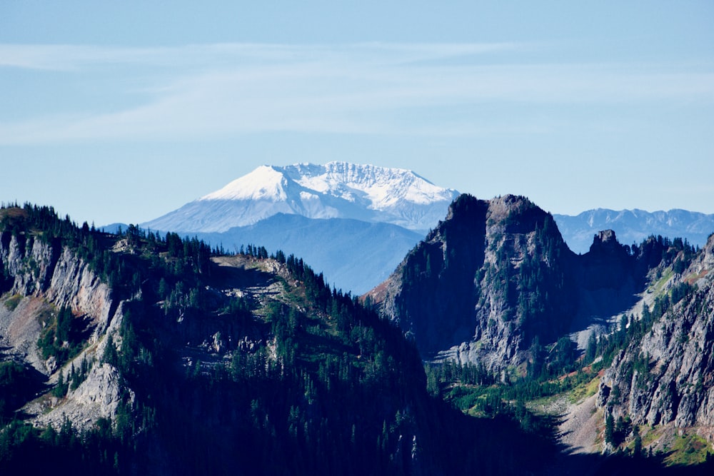 a mountain range with a snow capped peak in the distance