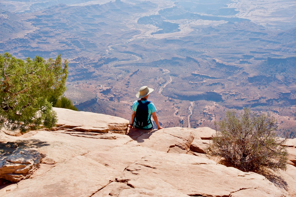 a person sitting on top of a large rock