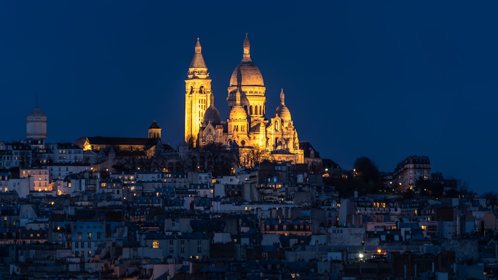 Eine sehr hohe Kathedrale, die nachts über einer Stadt thront