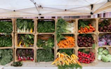 a variety of vegetables are displayed in wooden crates