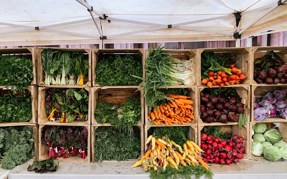 a variety of vegetables are displayed in wooden crates