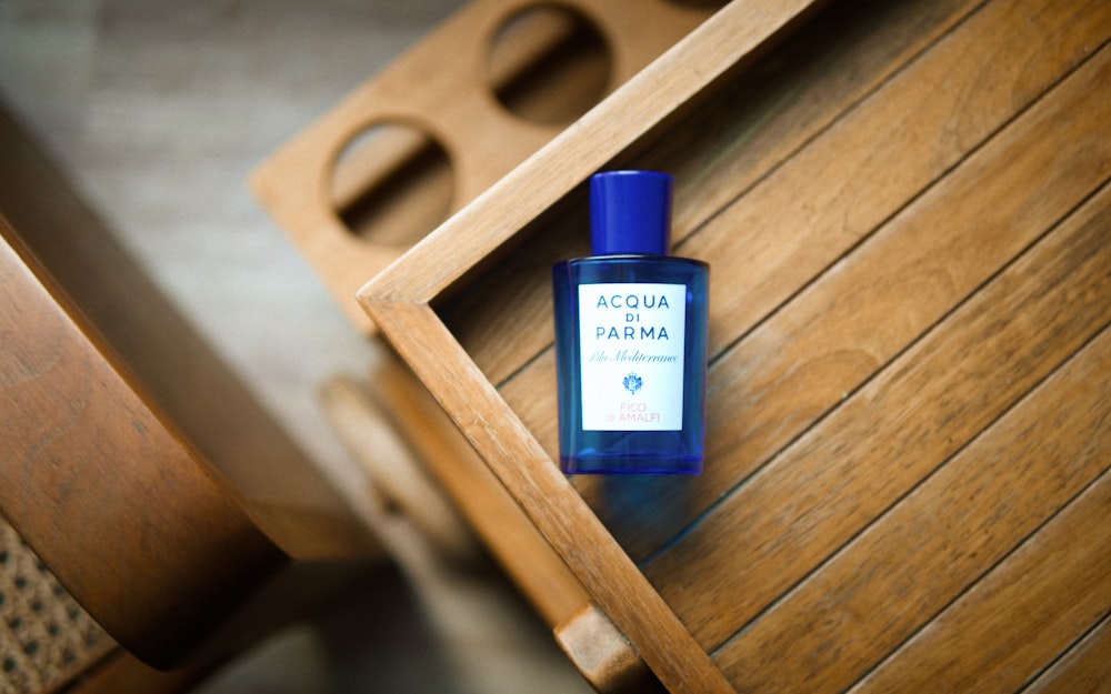 a bottle of acqua parma on a wooden table