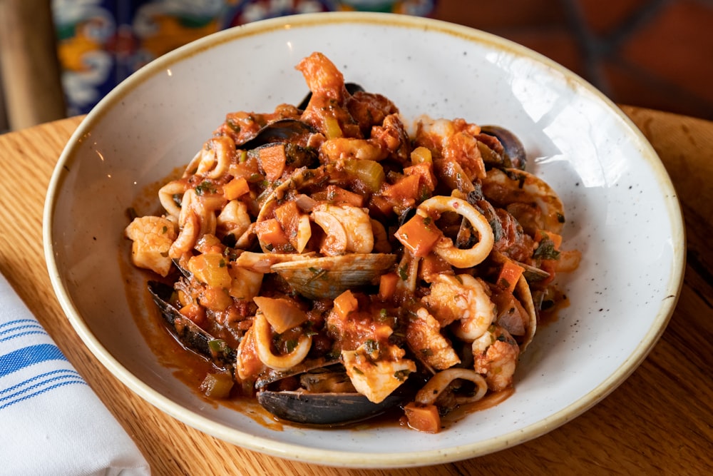 a white bowl filled with pasta and clams