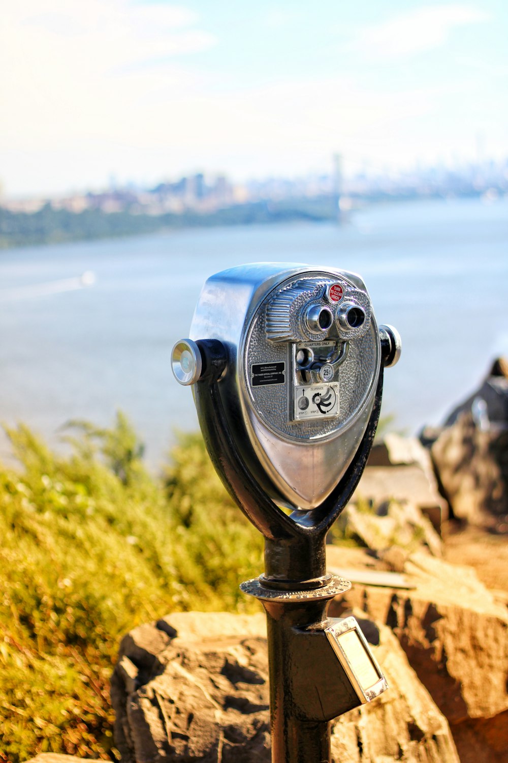 a coin operated parking meter overlooking a body of water