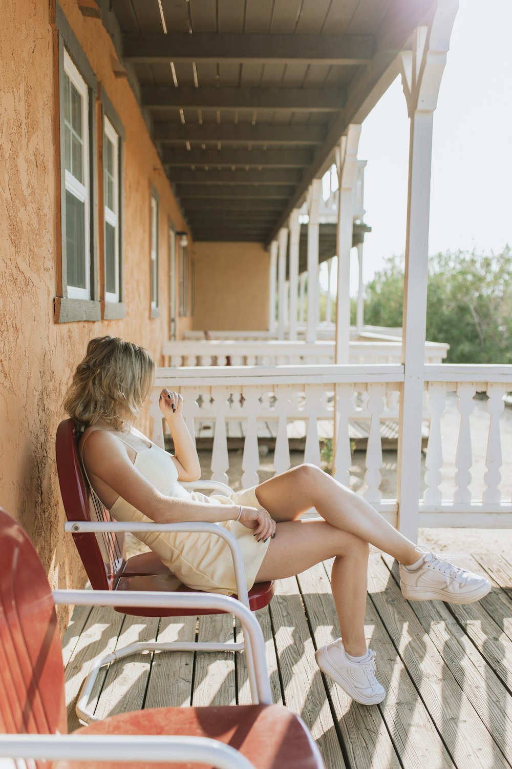 Una mujer sentada en una silla en un porche
