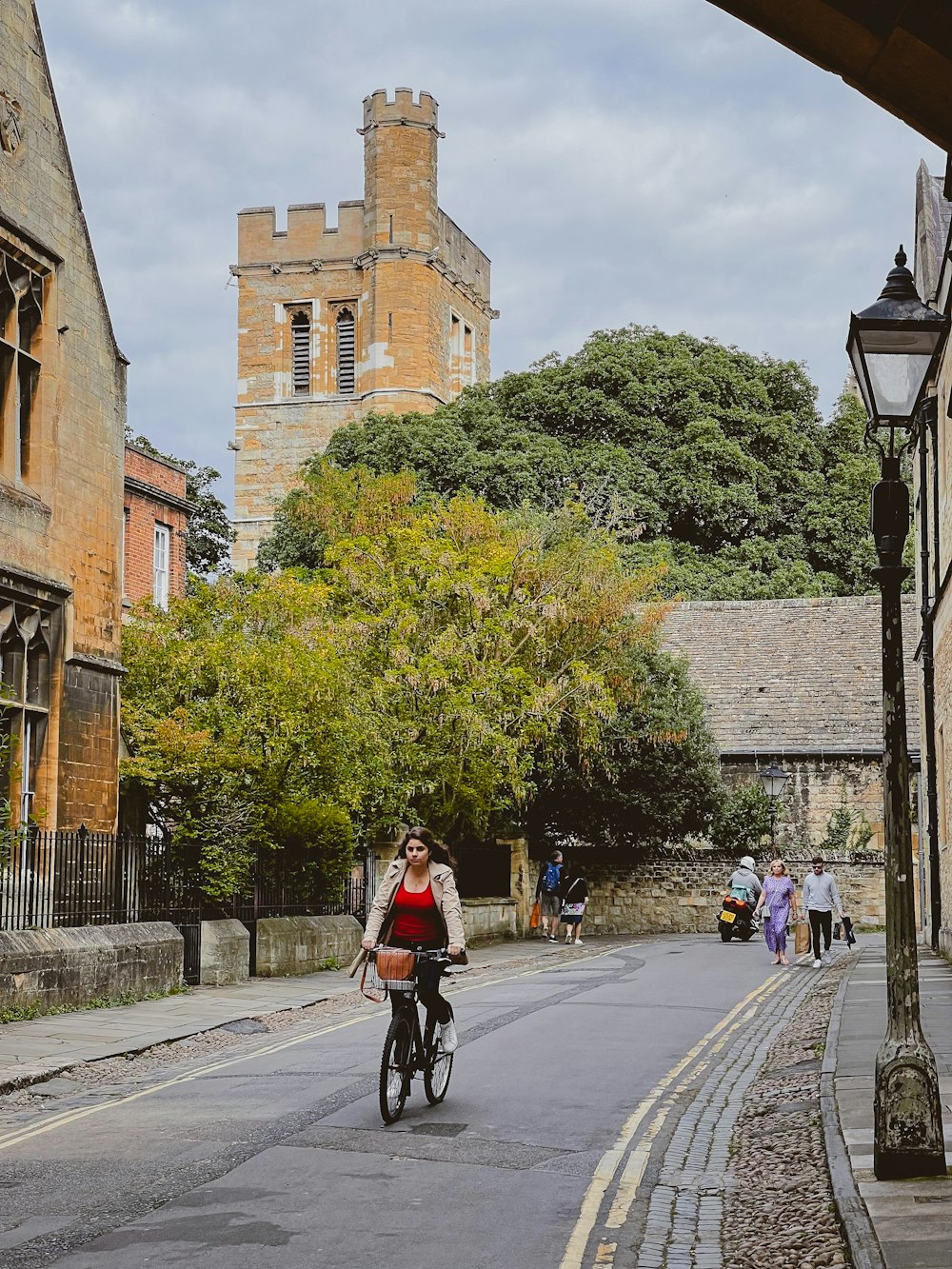 a woman riding a bike down a street next to tall buildings