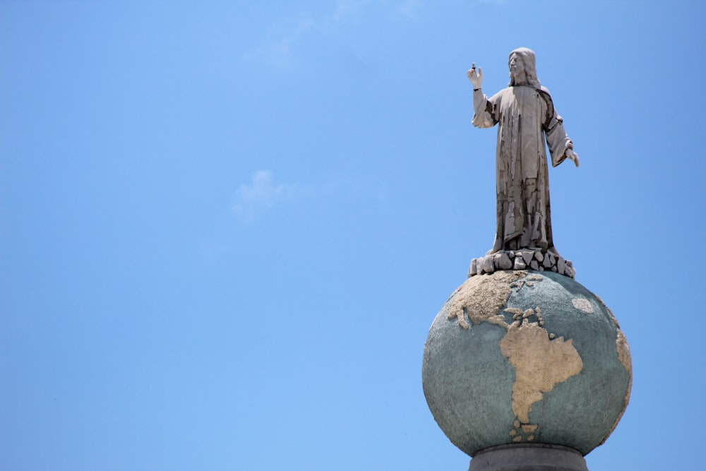 une statue d’une personne au sommet d’un bâtiment