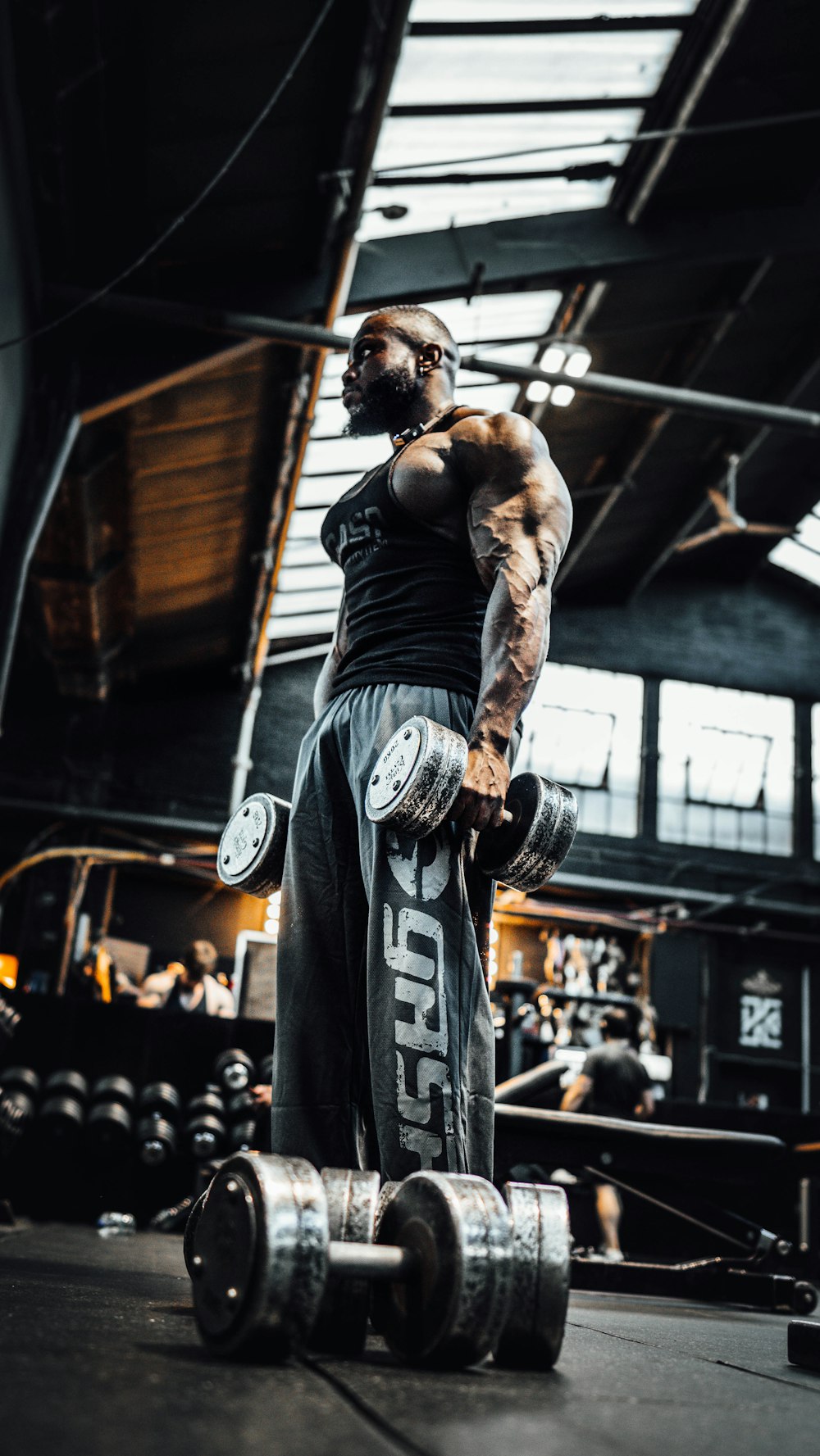 a man standing in a gym holding a barbell