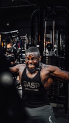 A trainer demonstrating muscle-building techniques with gym equipment.