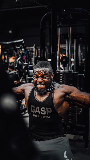 Close-up of a man wearing a sleek compression t-shirt during an intense workout session in a modern gym.