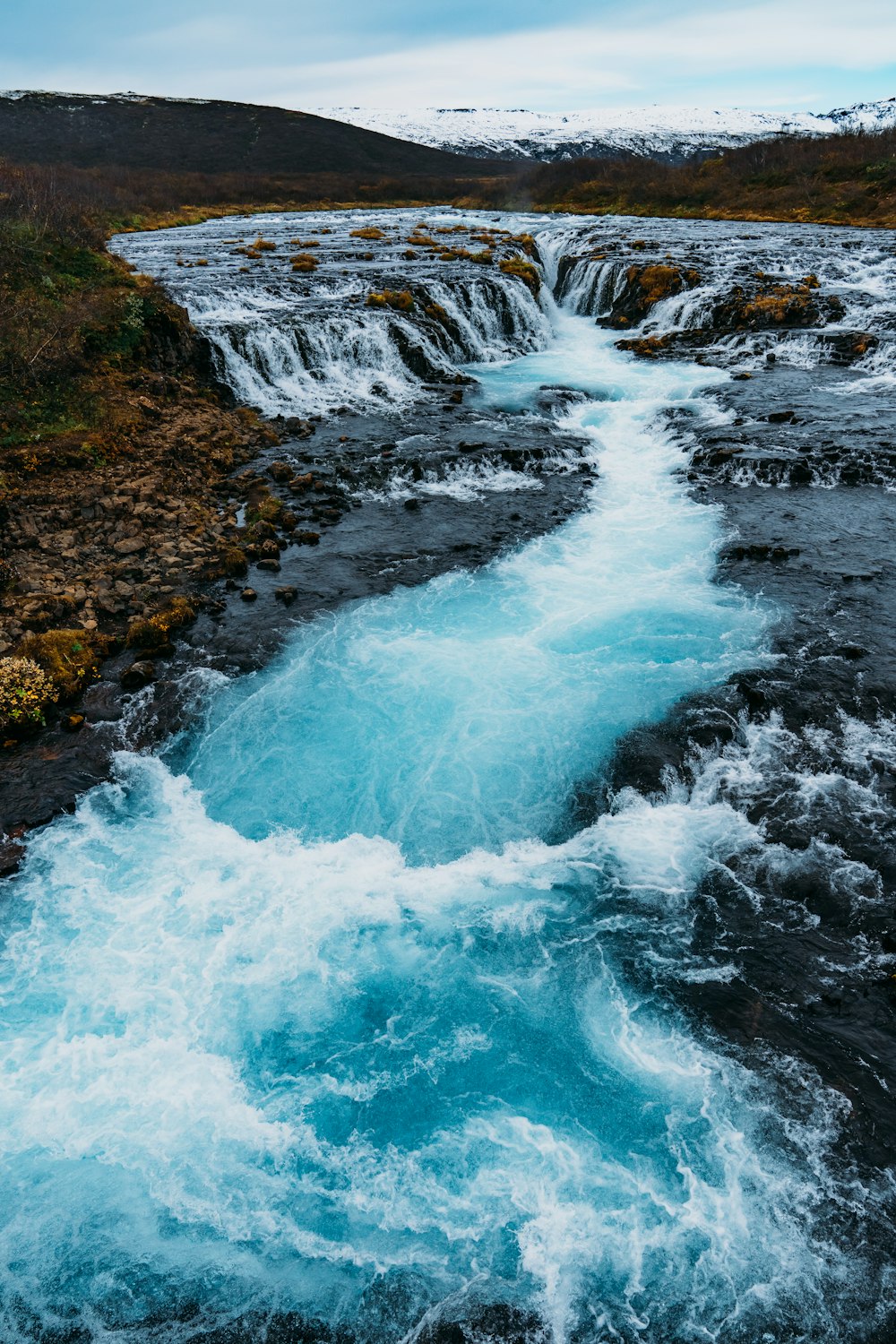 a stream of water running through a lush green field