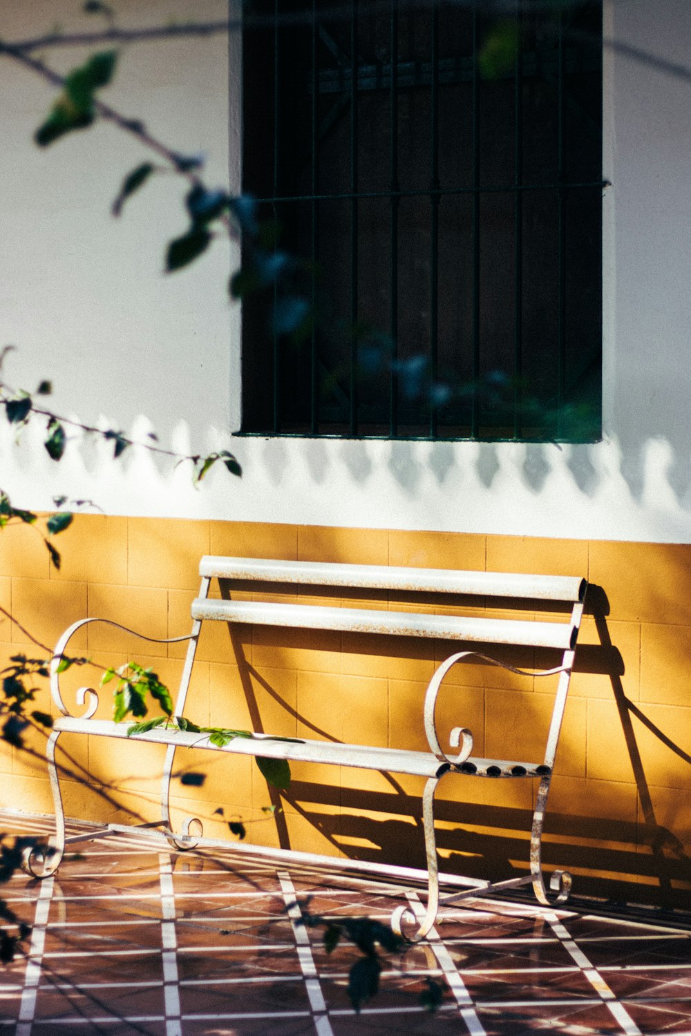 a white bench sitting in front of a building