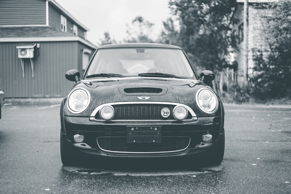Una foto en blanco y negro de un automóvil en un estacionamiento