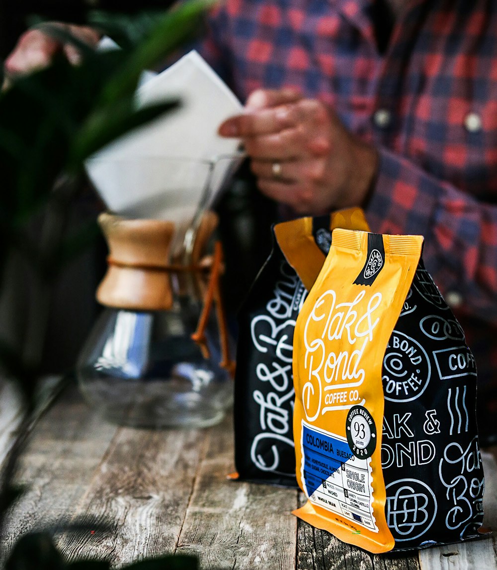 a person sitting at a table with a bag of coffee