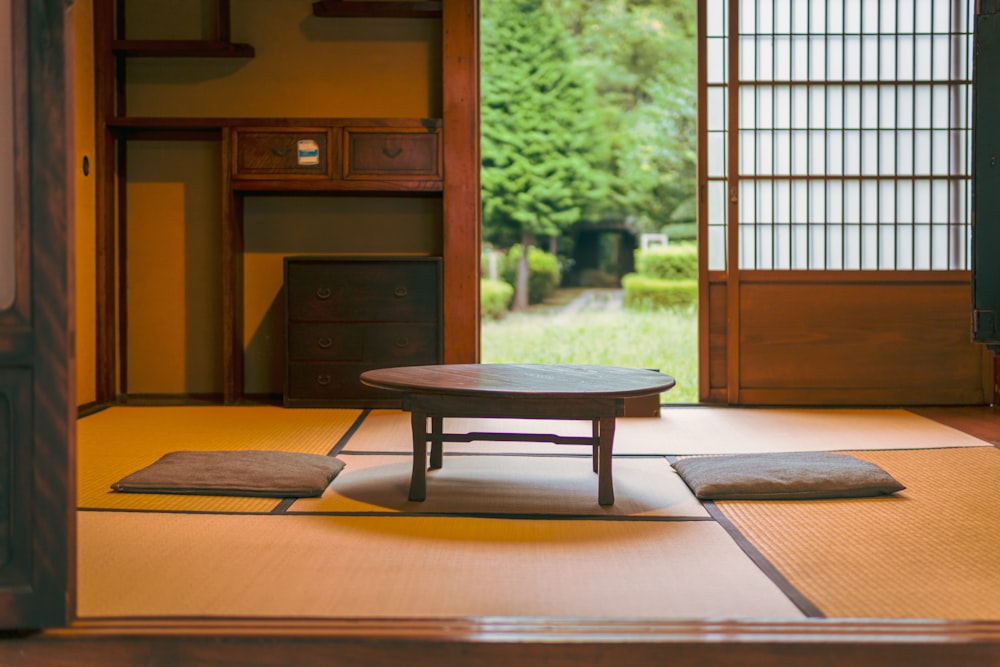 a room with a table and rugs on the floor