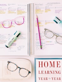a notebook with glasses and a book on it