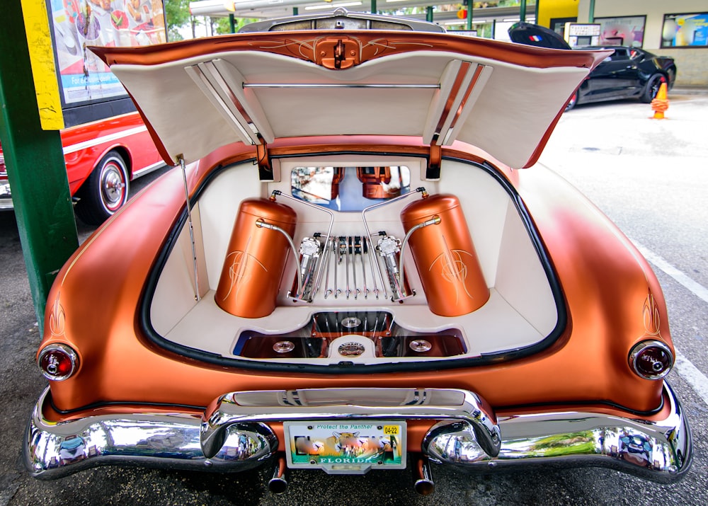 an orange and white car with its trunk open