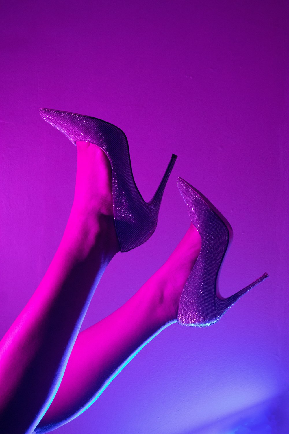 a pair of high heeled shoes in a purple room