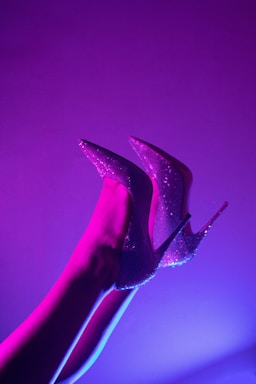 a pair of purple high heeled shoes on a woman's leg
