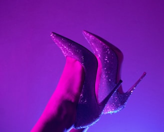 a pair of purple high heeled shoes on a woman's leg