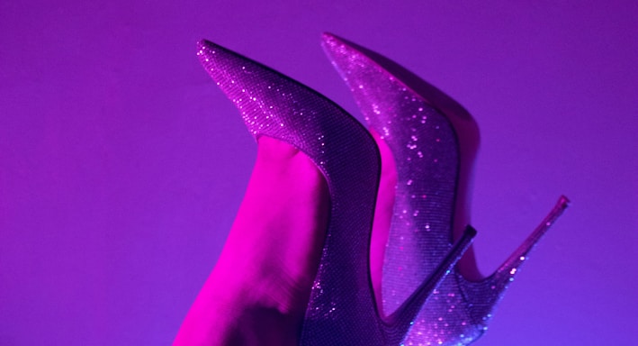 a pair of purple high heeled shoes on a woman's leg