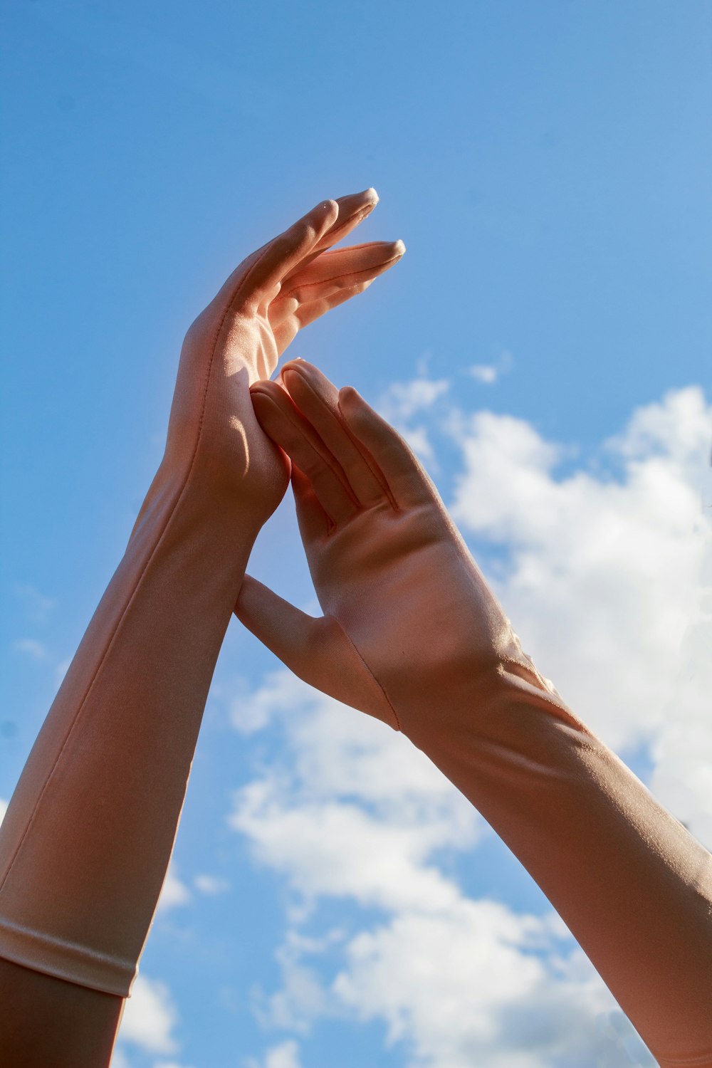 a pair of hands reaching up into the sky