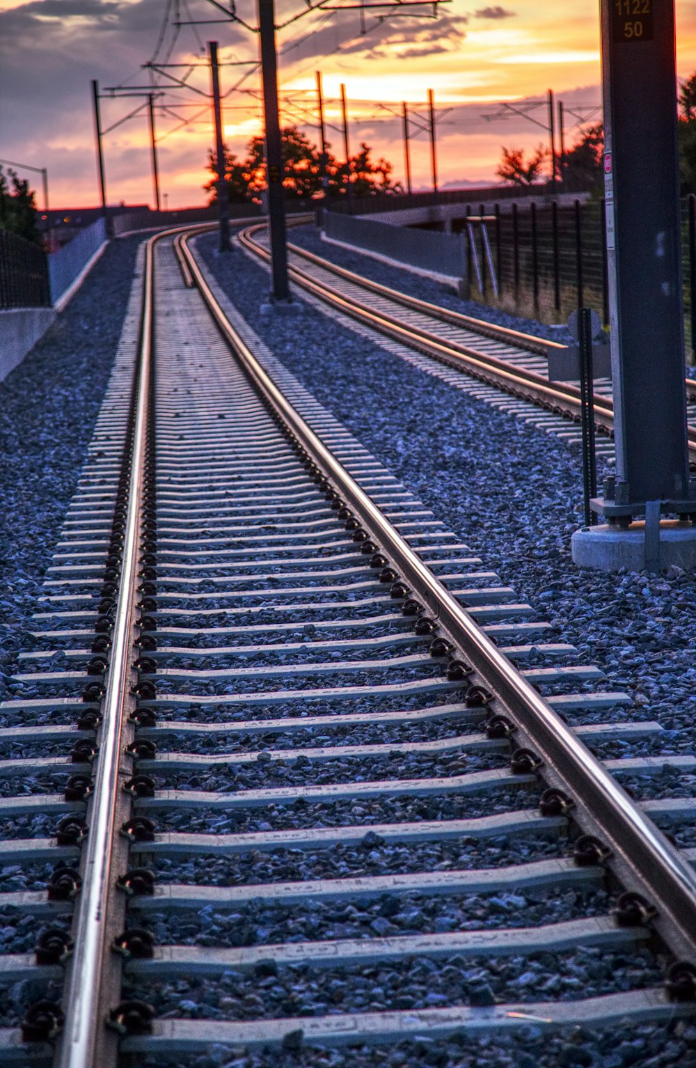 a train track with a sunset in the background