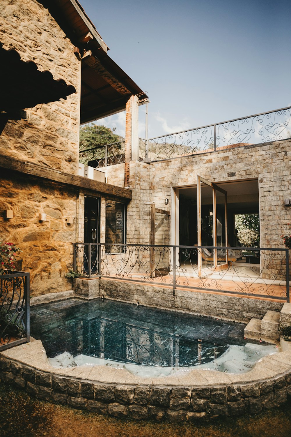 a stone house with a pool in the middle of it