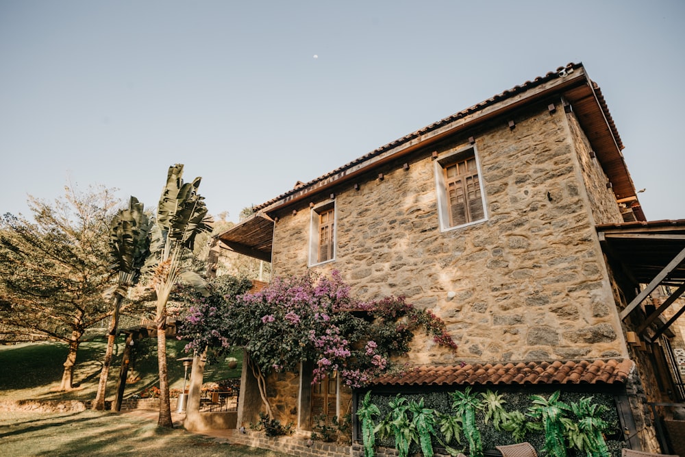 a stone house with a tree in front of it