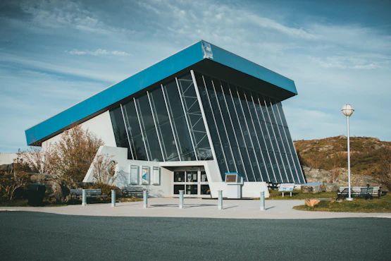 a large building with a blue roof on a sunny day