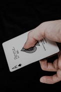 a person holding a playing card in their hand