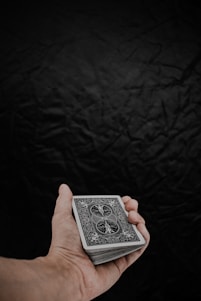 a person holding a playing card in their hand