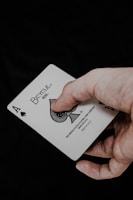 a person holding a playing card in their hand